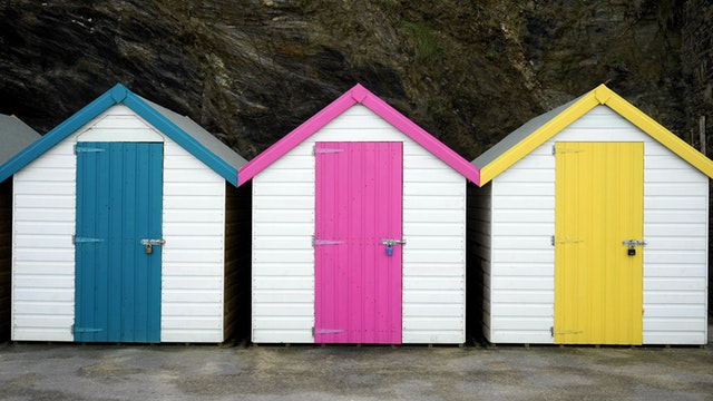 Tri biele domčeky s ružovými, modrými a žltými dverami